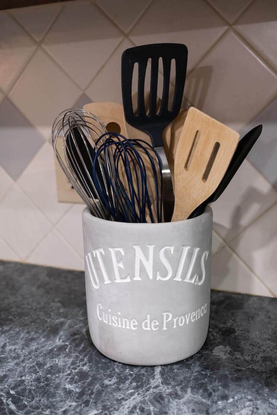 Functional meets elegant with cooking utensils neatly stored in a charming porcelain vessel.