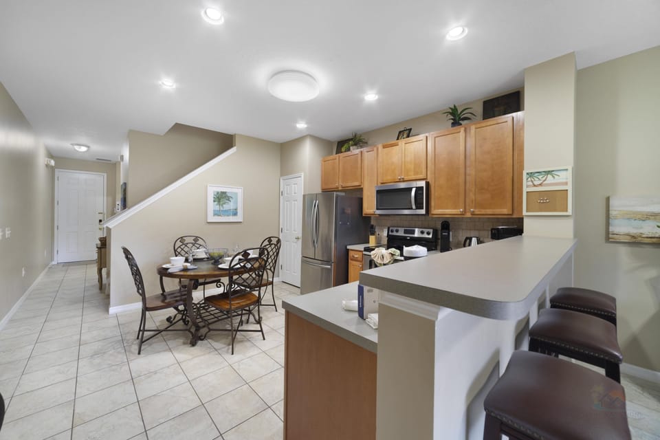 Modern kitchen with breakfast bar and dining area, perfect for family gatherings.