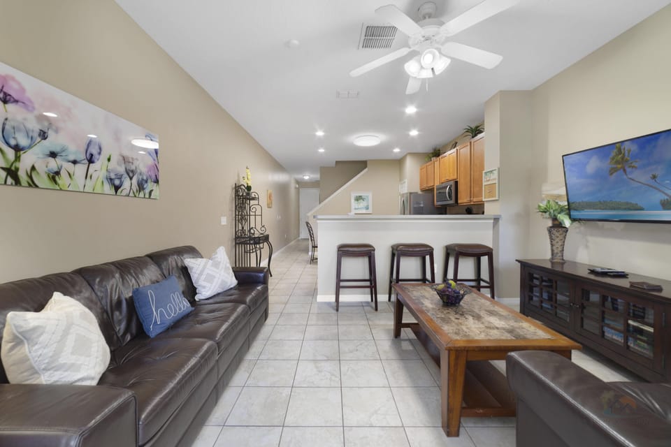 Open-concept living area with comfy leather seating and a breakfast bar for casual dining.