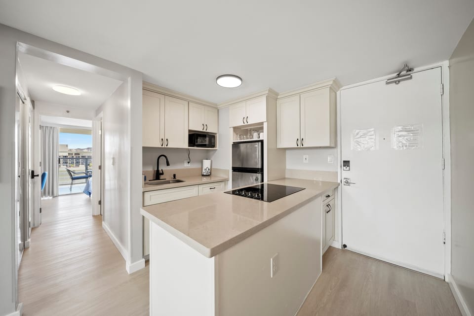The kitchen features four burner’s glass stovetops & a full-sized refrigerator.