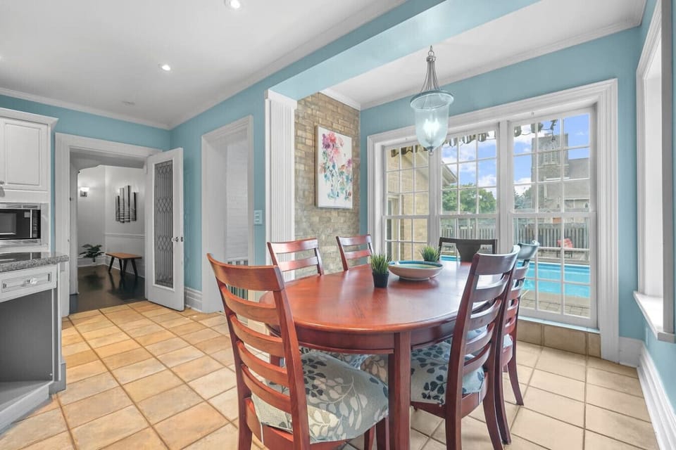 Gather for a delicious meal with a view. The dining table sits by a large window overlooking the pool, filling the space with natural light. It`s the perfect setting for memorable meals with family and friends.