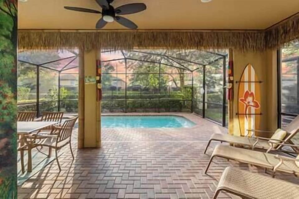 Pool deck with heated pool and spa, sound lounge chairs, and outdoor dining table.