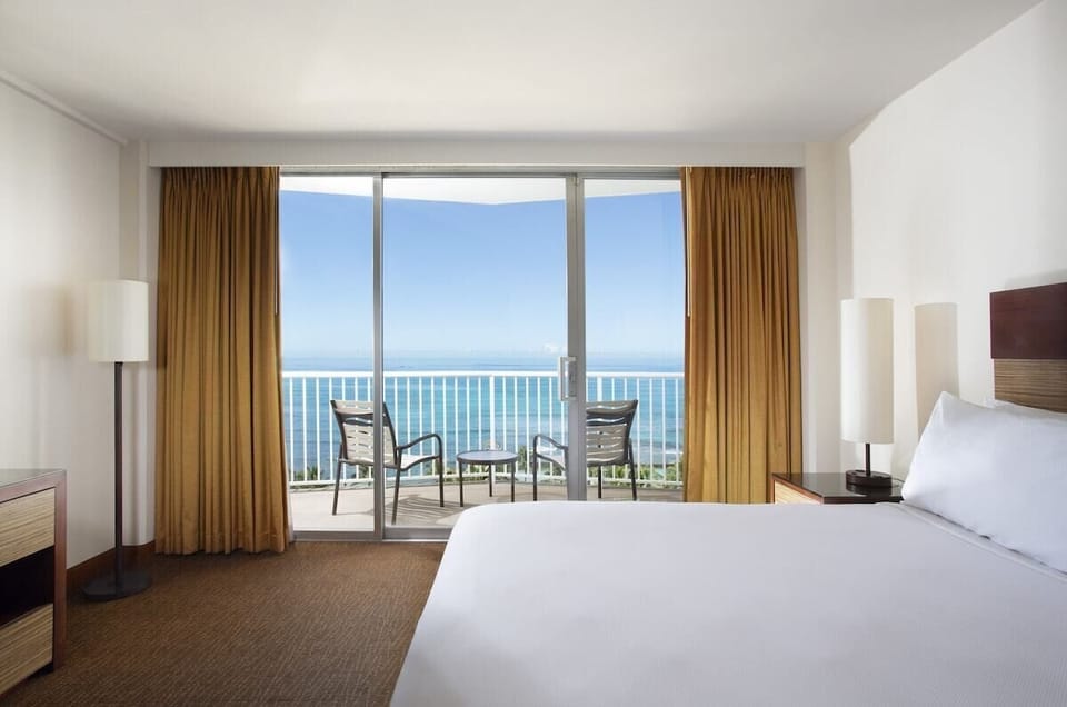 Wake up to endless blue horizons framed by golden drapes.