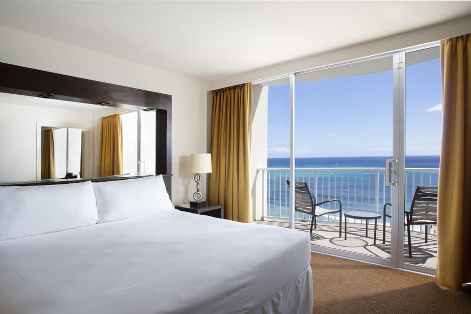 Unwind in a plush king bed with oceanfront balcony.