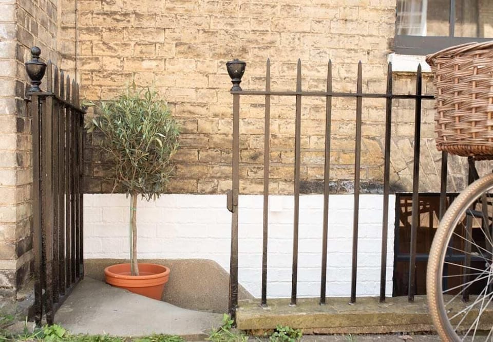 A gated entrance to a cozy basement-style flat, offering privacy and security in a serene setting.
