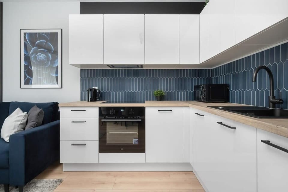 A full kitchen setup with white cabinetry and dark countertops.
