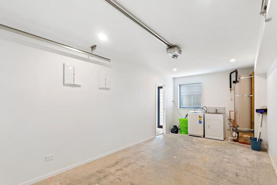 The laundry has a top-loading washing machine and laundry tub.