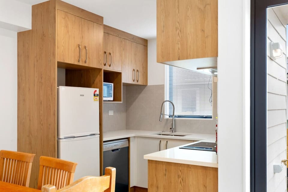 Although compact, the kitchen has a oven, cooktop, dishwasher, microwave and fridge/freezer.