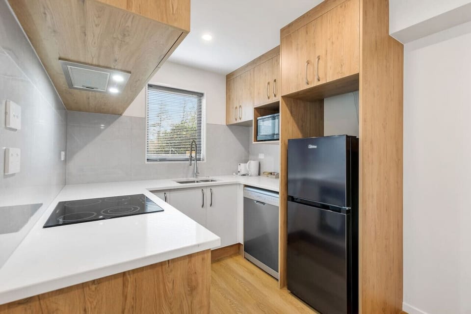 Although compact, the kitchen has a oven, cooktop, dishwasher, microwave and fridge/freezer.