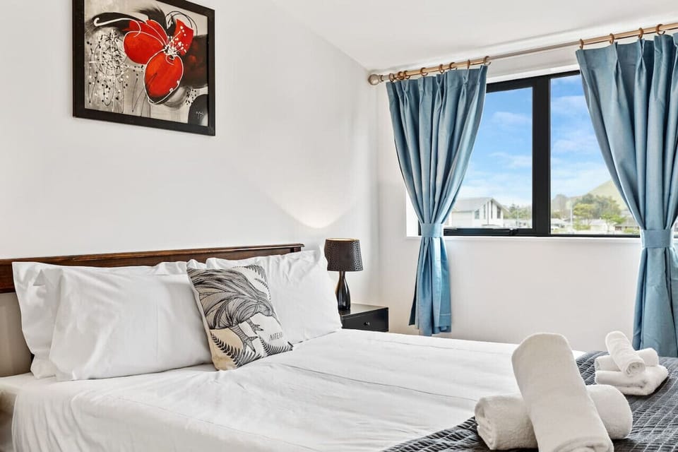 The bedroom exudes calm and serenity, bathed in soft, natural light streaming through the window.