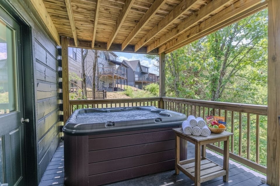 Private covered deck with bubbling hot tub is perfect for unwinding.