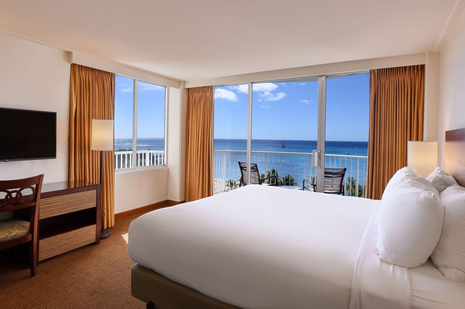 Wake refreshed beside panoramic windows overlooking the open ocean.