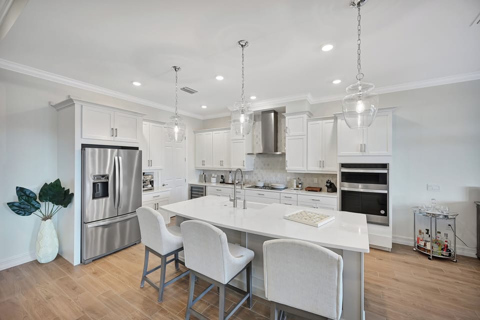 Modern gourmet kitchen with custom high end appliances & wine fridge.