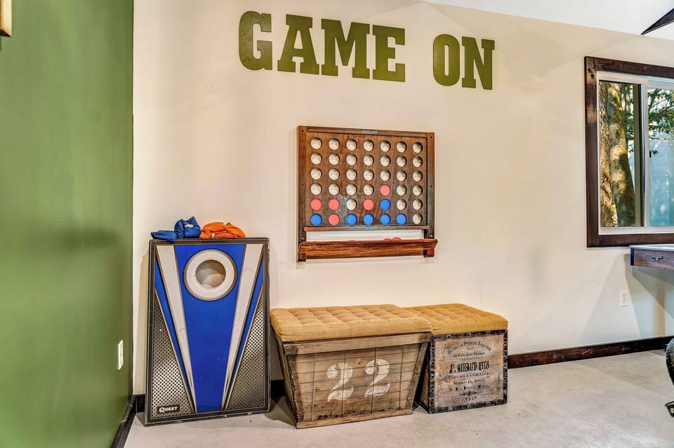 The detached game room is a standout feature, offering cornhole, air hockey, pool table, XL Connect Four, a Smart TV, cozy lounge chairs, a bar top, and charming string lights to elevate the experience. Plus, it's own heat and air conditioning unit! 