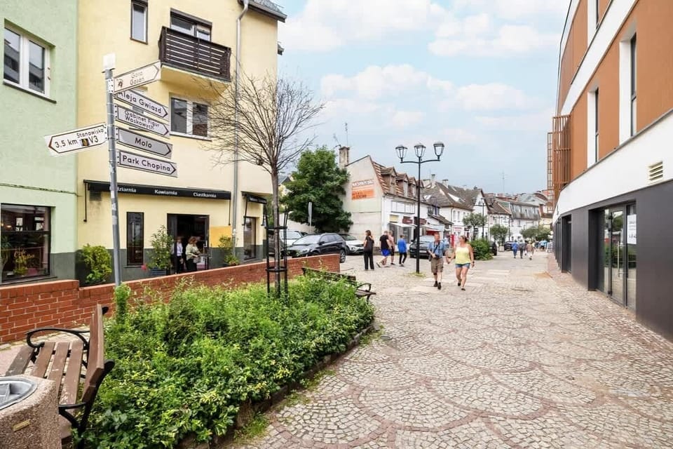 A view of a cobblestone street lined with shops and trees. Perfect for a leisurely walk in the neighborhood.