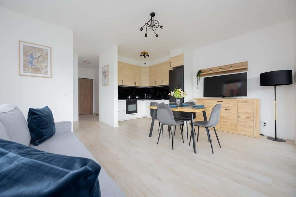 A cozy seating corner with a sofa, wall decor, and direct access to the adjacent dining and kitchen zones.