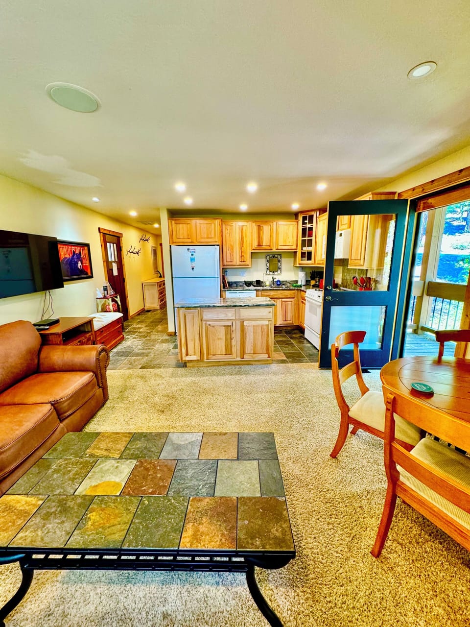 Open concept kitchen / living / dining space opens up to the deck outside.