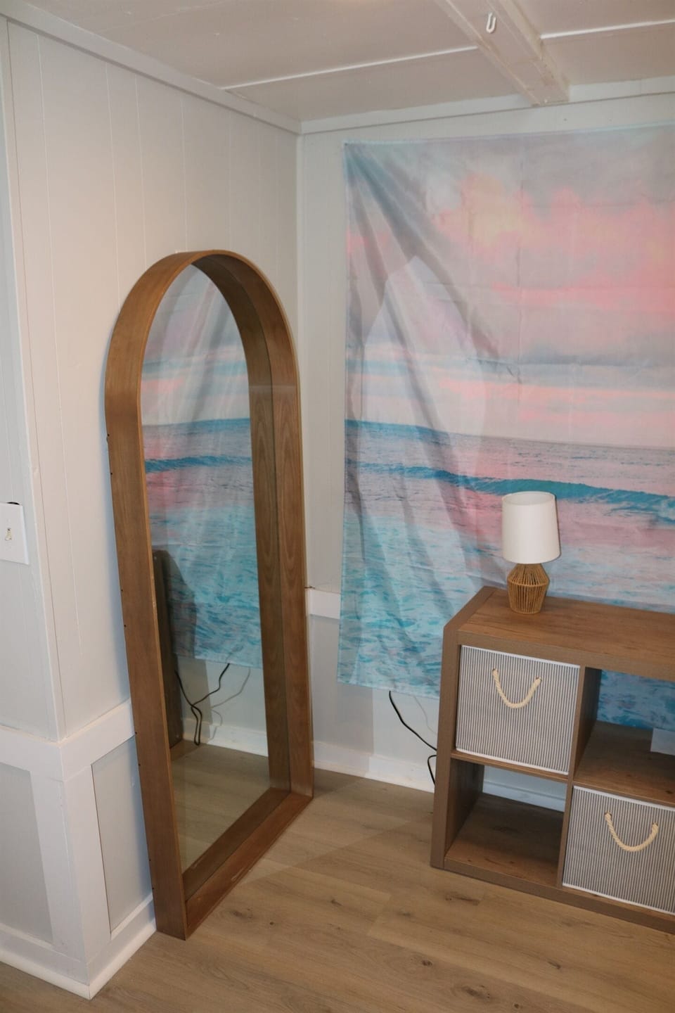 full size framed mirror sits alongside the storage dresser