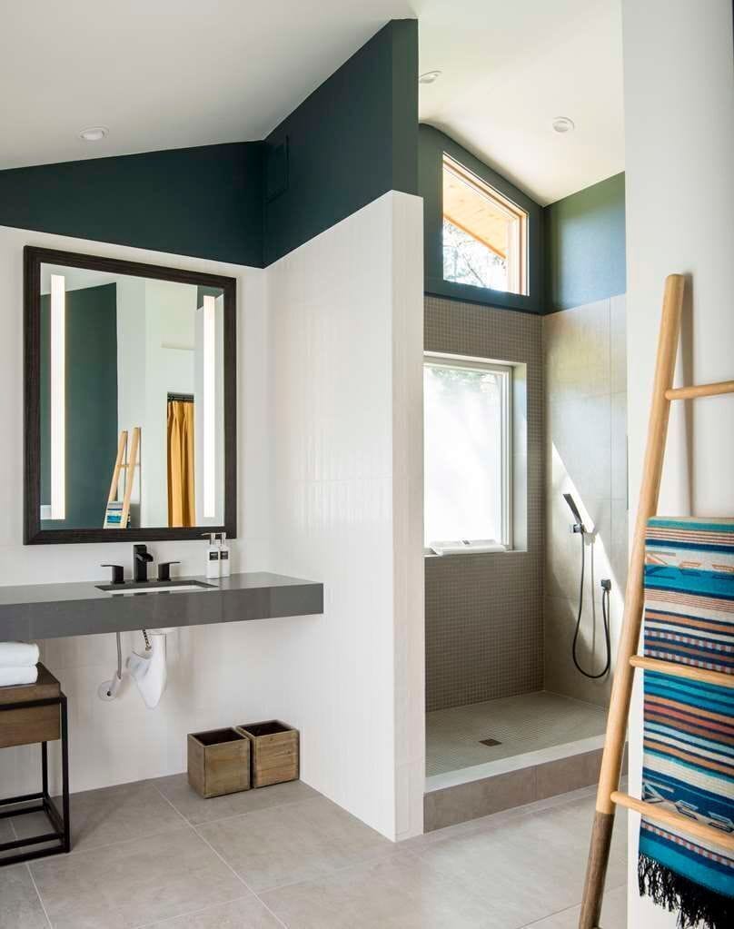 Modern bathroom with elegant fixtures and ample natural light, perfect for a refreshing start to your day.