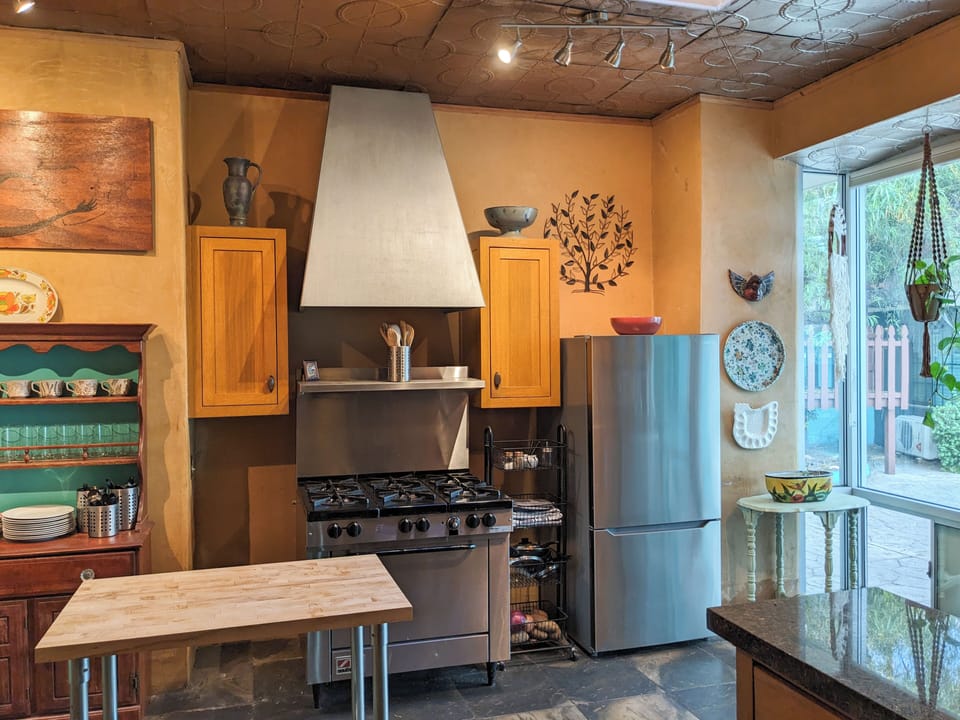 Beautiful kitchen with large window wall overlooking the pool and treehouse.