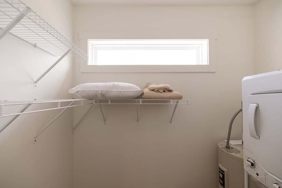Spacious walk-in closet with in-unit washer and dryer, offering convenience for longer stays and extended visits.