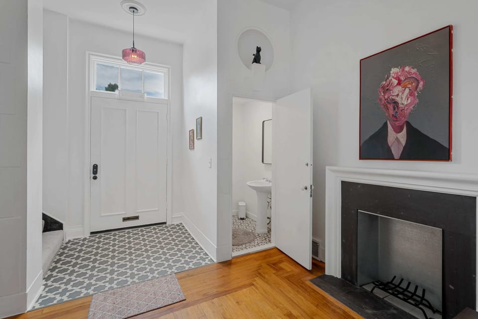 Embrace the elegance of simplicity in a white room adorned with a captivating painting on the wall.