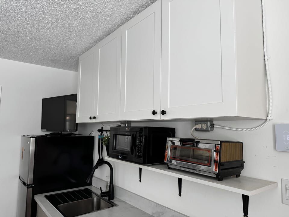 Queen bed, dining area, kitchenette with fridge, cooktop, microwave, toaster.