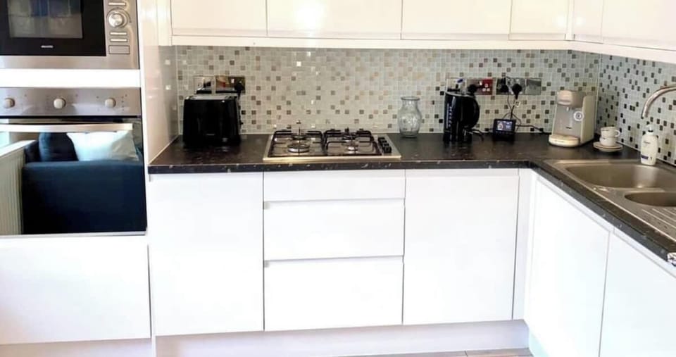This sleek, modern kitchen flows directly into the living area. It is fully equipped with an oven, microwave, and gas stovetop.