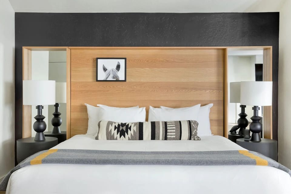 Sink into crisp linens beneath a bold, modern headboard.
