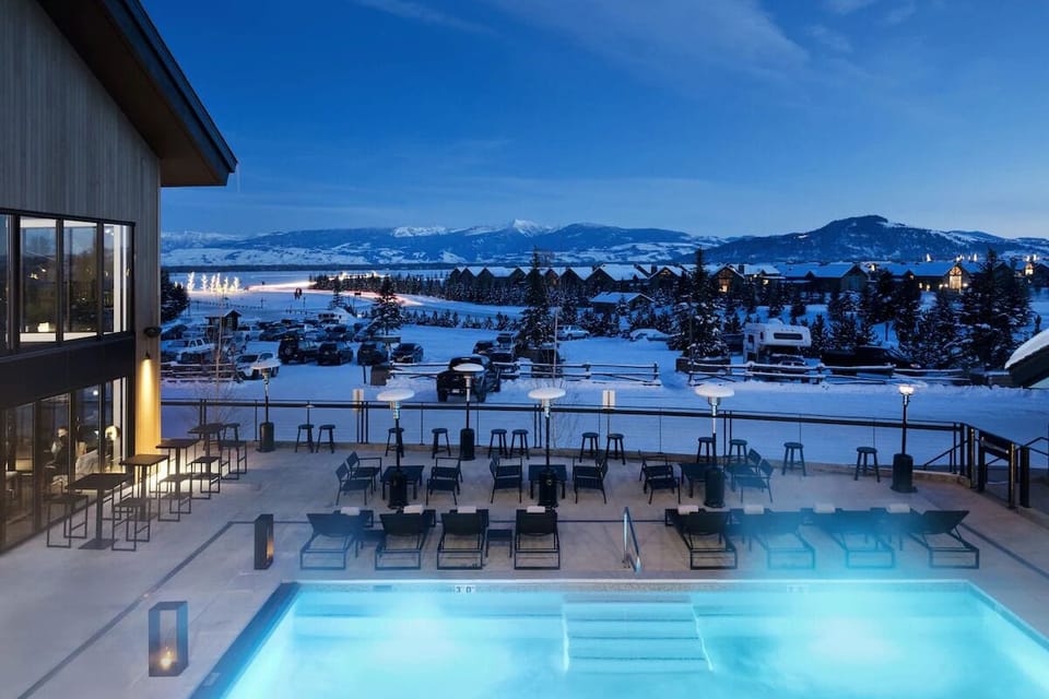 Unwind in the heated pool as snowy peaks glow.