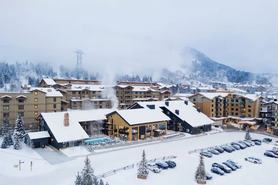 Arrive to a snowy lodge exterior with steaming poolside views.