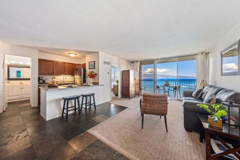 Cook and gather in an open‑plan space where dark wood and ocean views meet at the breakfast bar.