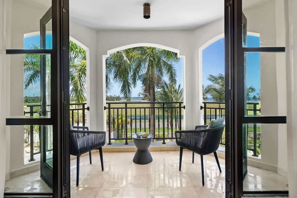 Step onto your private oasis and indulge in breathtaking views. This inviting balcony, complete with plush seating and a stylish side table, offers the perfect escape to unwind and soak in the stunning scenery. From the lush greenery to the sparkling