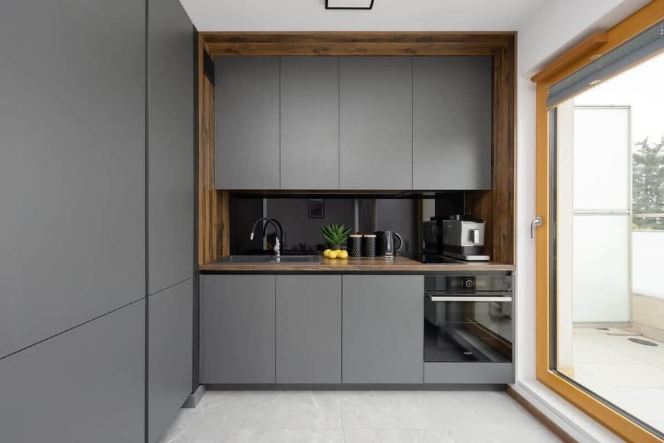 A modern fitted kitchen with access to the balcony offers functionality and convenience while cooking.