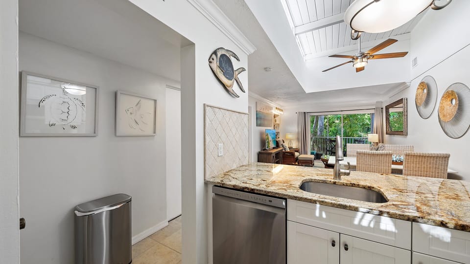 Thoughtful coastal art and convenient access to the hallway, living room, and fully-equipped kitchen demonstrate the seamless, guest-focused design of this Longboat Key condo.