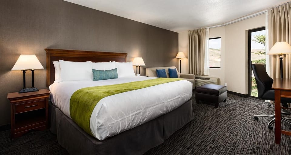 Unwind in a plush king bed with cozy lounge corner.