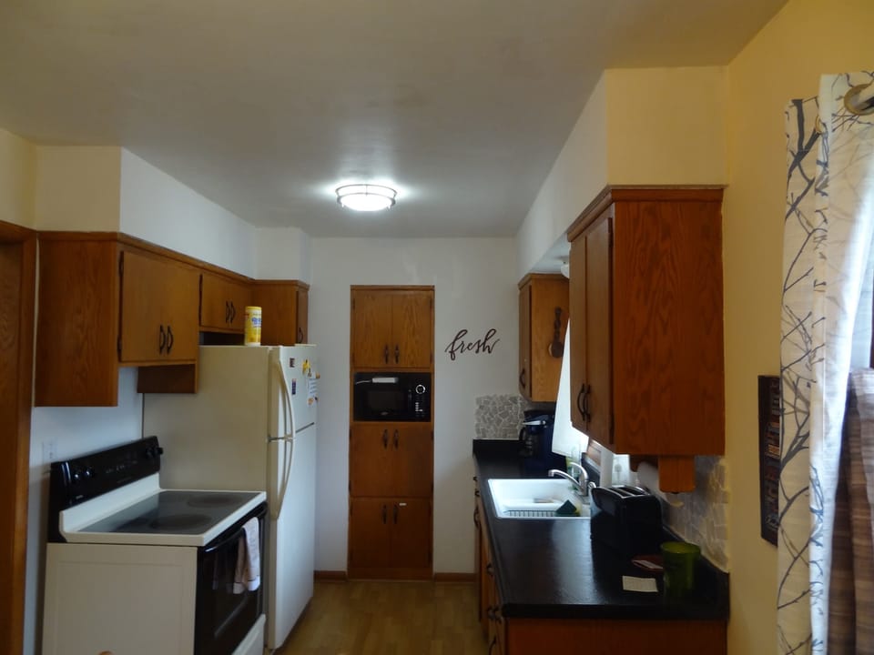 Kitchen with stove, full refrigerator, and most essentials