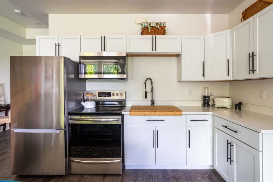 Cook in style in our modern kitchen with stainless steel appliances, white cabinetry, & sleek countertops. Perfect for meals after a day at Indiana Dunes. Equipped with air fryer oven, cutting board, toaster, & tea kettle for your convenience.