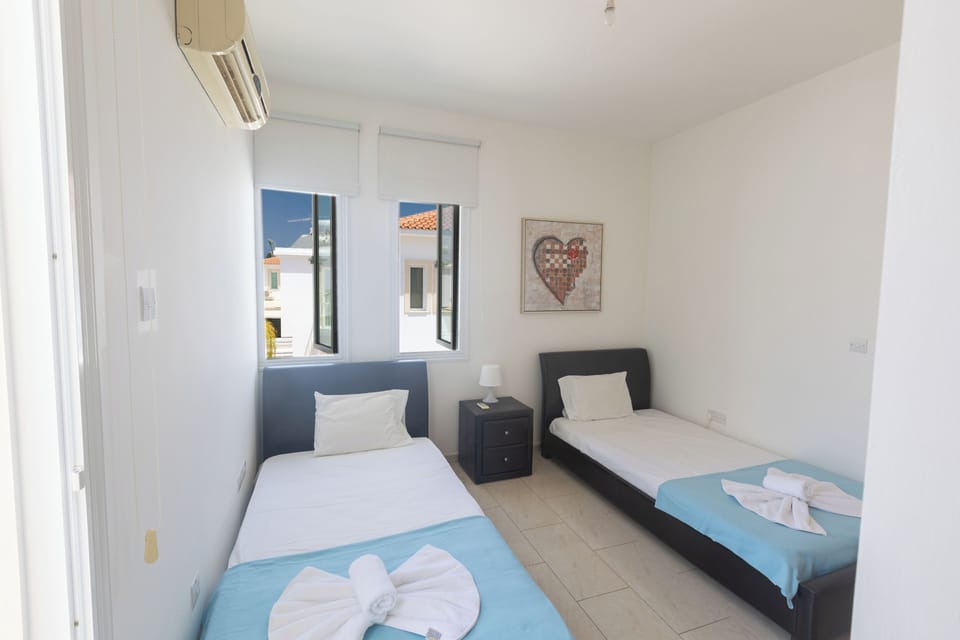 Bedroom 2 with two single beds and shared balcony