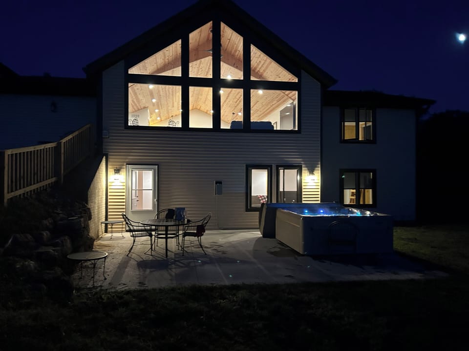 House at night with lighted hot tub.