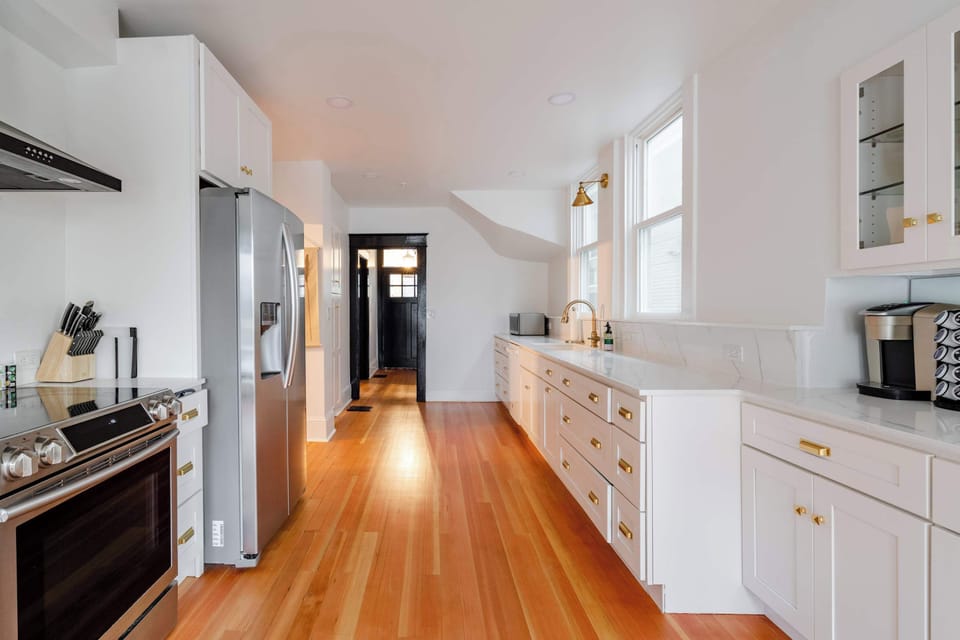 Kitchen 1 with white cabinetry and warm wood floors.