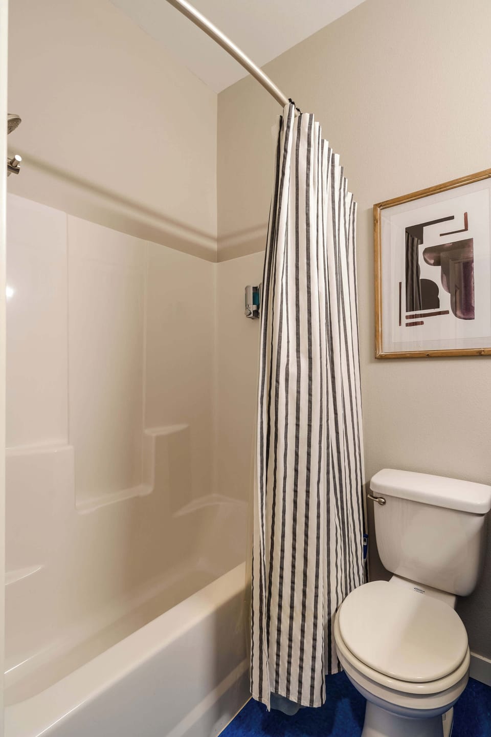 Bathtub with shower beside a tiled bathroom floor.