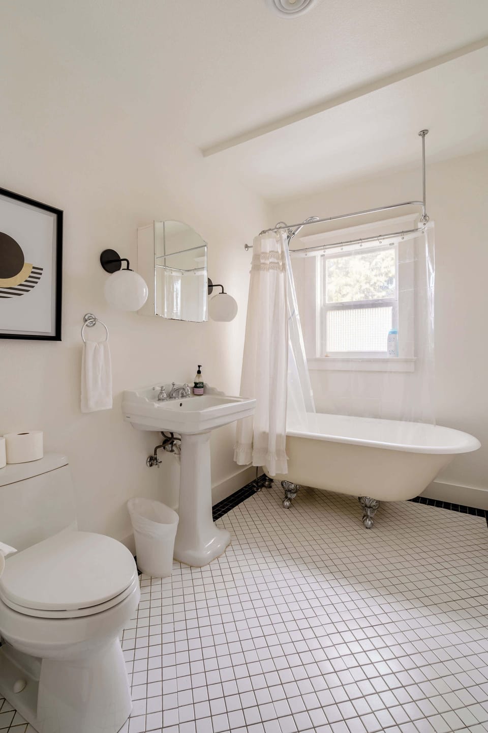 Bathroom with a clawfoot bathtub and pedestal sink.