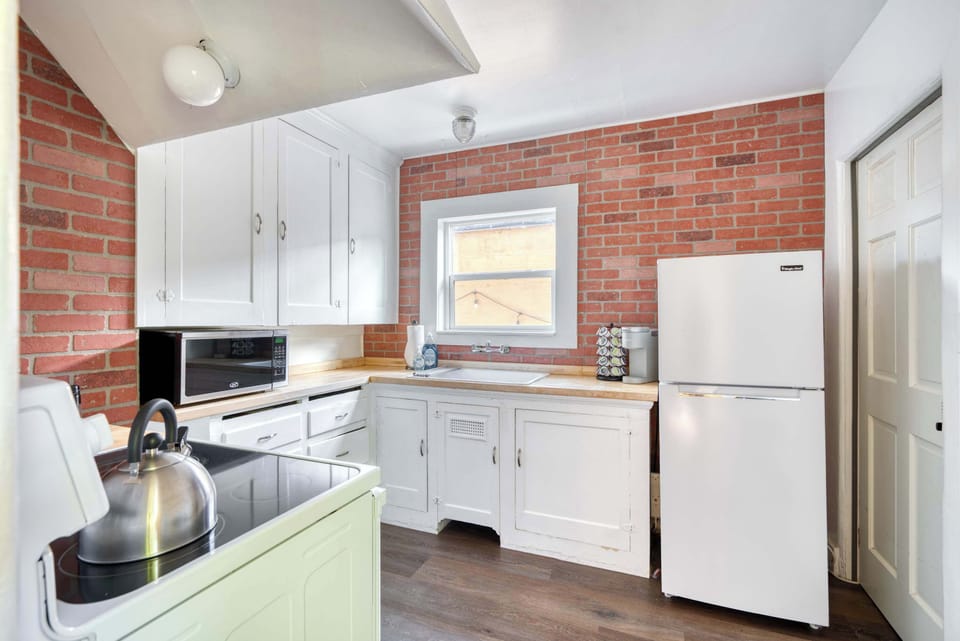 Kitchen with brick backsplash and white cabinets.