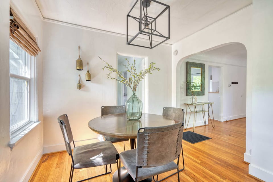 Dining room with round table and windows.