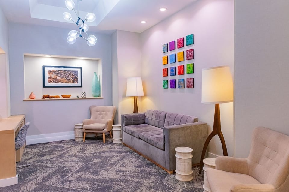 Unwind on plush seating beneath warm lighting and artful décor.