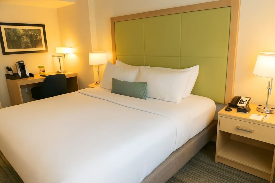 Sink into plush pillows under warm, calming bedside light.