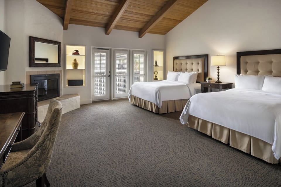 Stretch out in a spacious double-queen room with warm lighting.