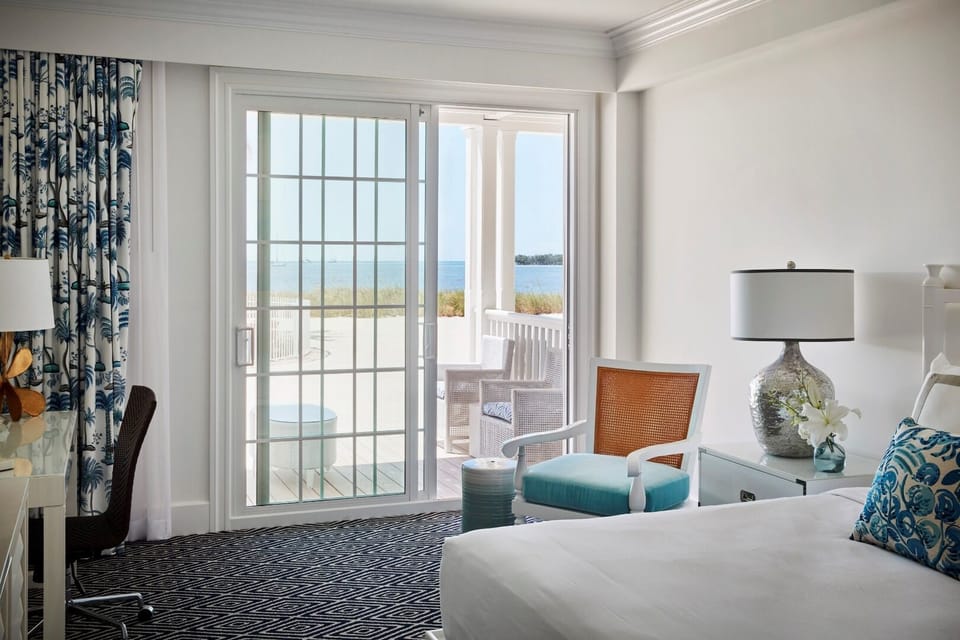 Breathe in coastal calm from bed with beach views ahead.