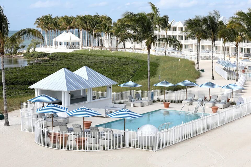 Gather poolside under striped umbrellas for effortless relaxation.